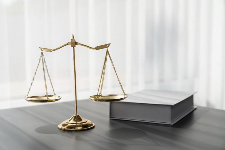Balance en laiton posée sur un bureau à côté d'un livre fermé