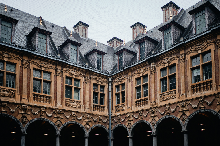 Cour intérieure à arcades d'un bâtiment historique en brique et pierre sculptée