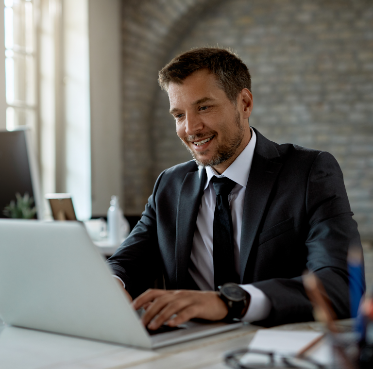 Conseiller souriant qui travaille sur un ordinateur portable à son bureau